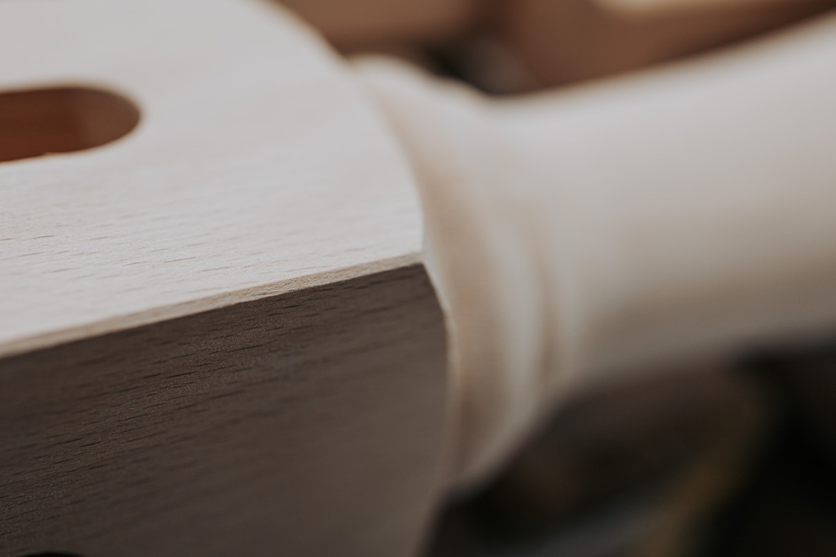 Close-up of hands working with natural wood - reflecting craftsmanship, sustainability, and attention to detail in furniture making
