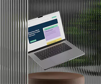 En svävande Macbook bakom en glasvägg.