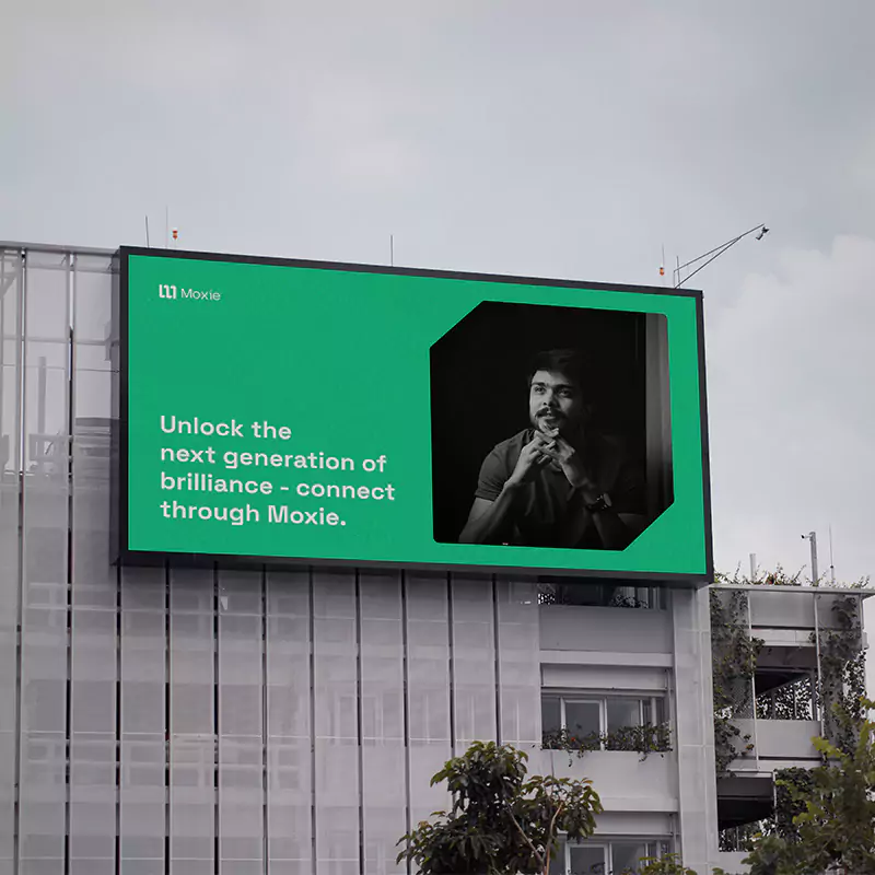 En grön Moxie anslagstavla på sidan av en byggnad.