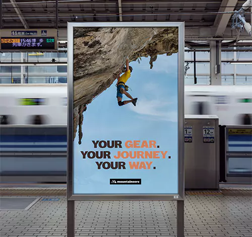 An outddors Mountaineers billboard on a train station.