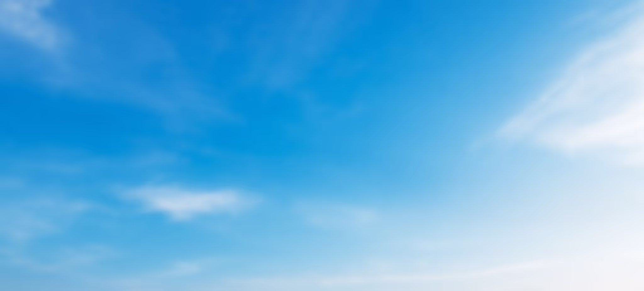 Clear blue sky with a few thin, wispy white clouds.