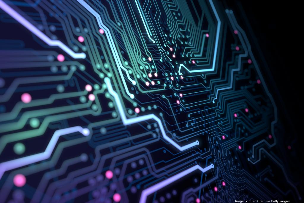 Close-up of a dark circuit board with glowing, neon-colored lines in blue, purple, and green, intersected by small, bright pink dots.