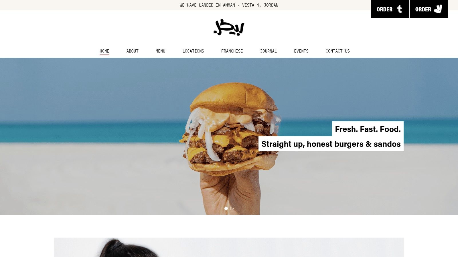 A cheeseburger and a drink sitting on a wooden ledge with a beach in the background, representing a quality local meal option.