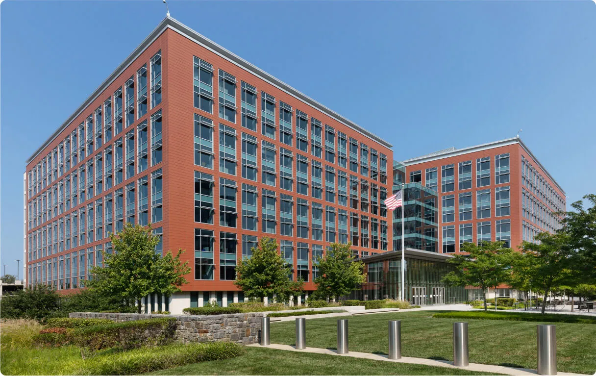A large red brick building with a grassy area in front of it.