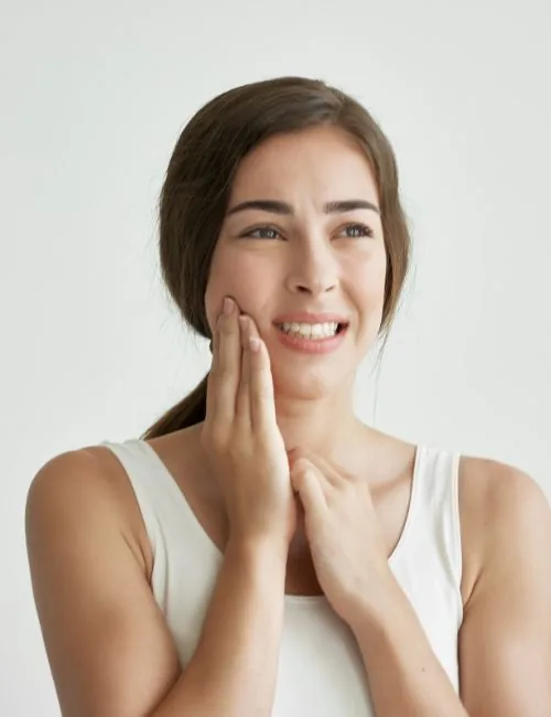 photo of a woman experiencing a toothache, hand on face