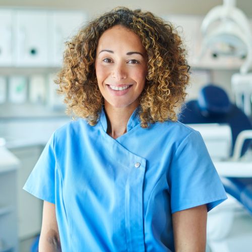 a woman in a blue shirt standing in a dental office