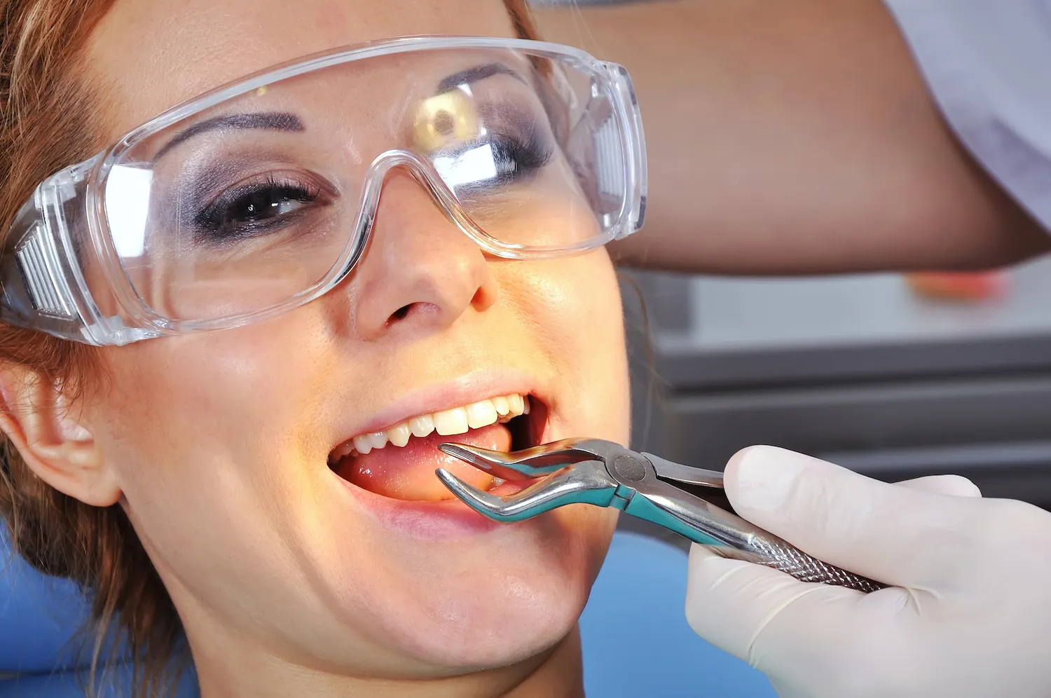 A woman having a tooth extracted by a dentist.