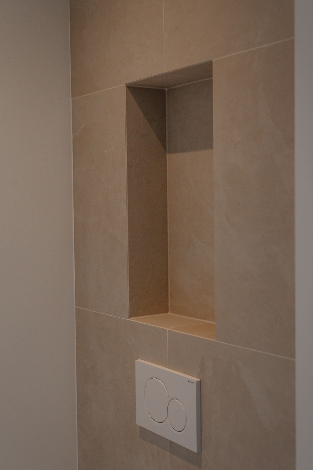 Modern toilet met beige tegels en steen wastafel