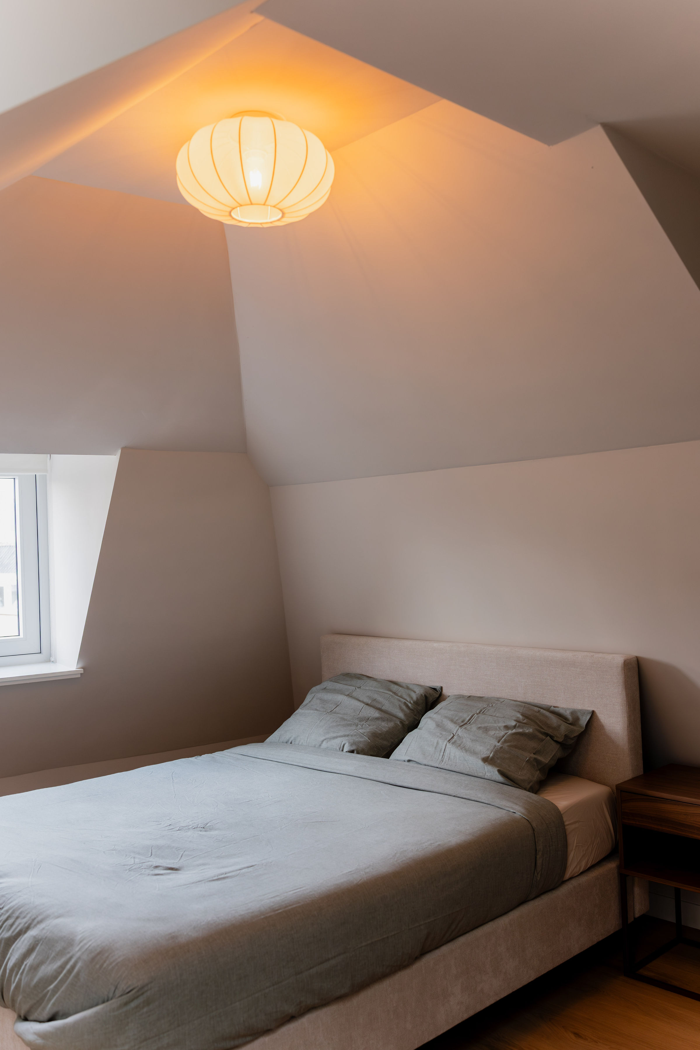 Gerenoveerd slaapkamer onder schuindak met warme neutrale tinten