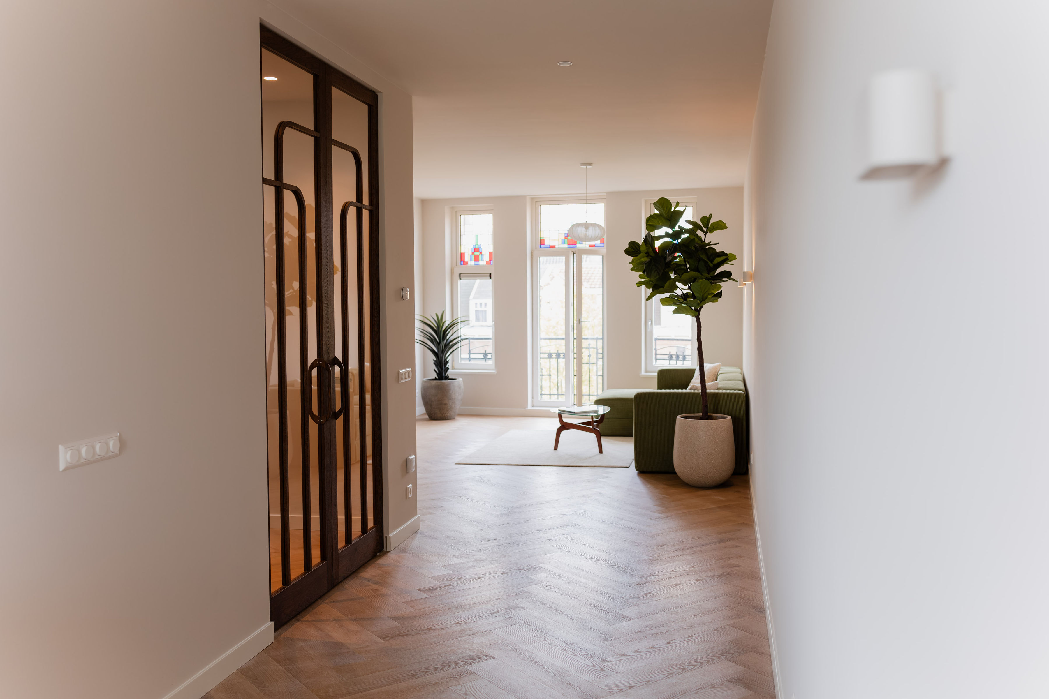 Woonkamer met maatwerk glasdeur en glas-in-loods