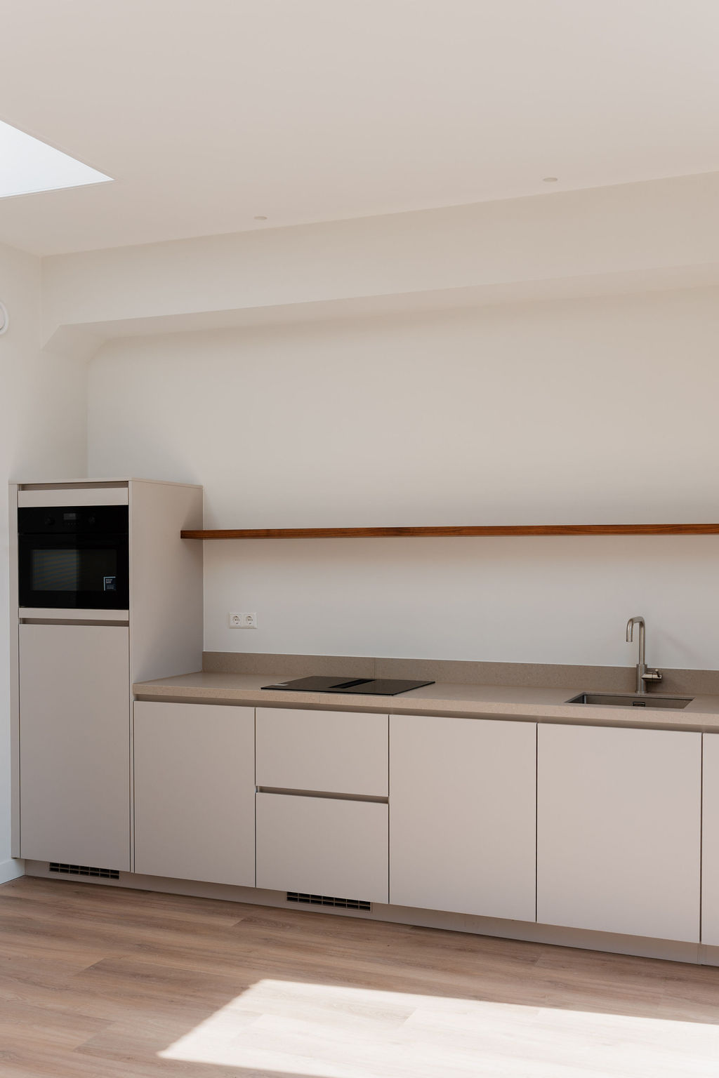 Moderne minimalistische keuken met daklicht en houten accenten