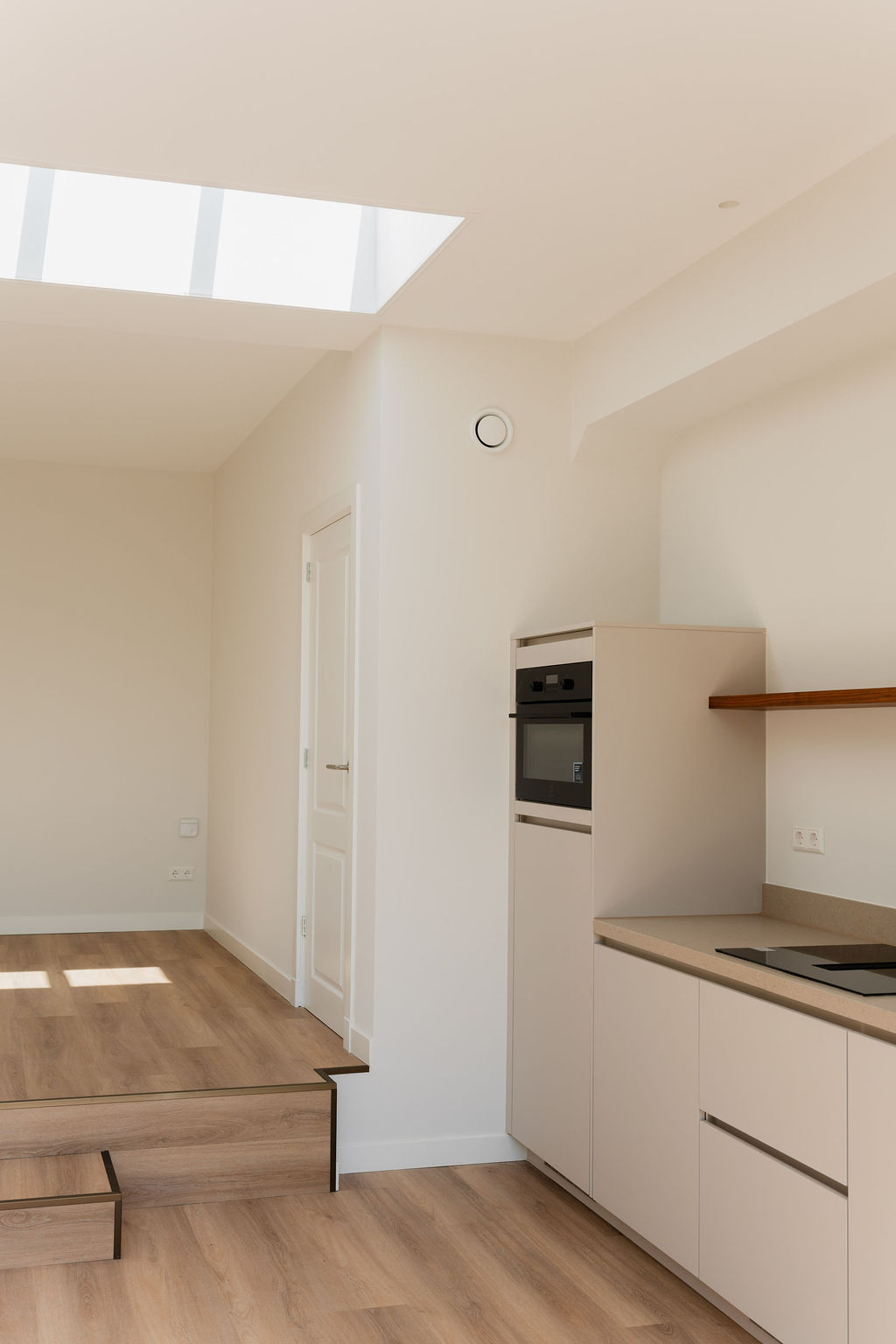 Moderne minimalistische keuken met daklicht en houten accenten