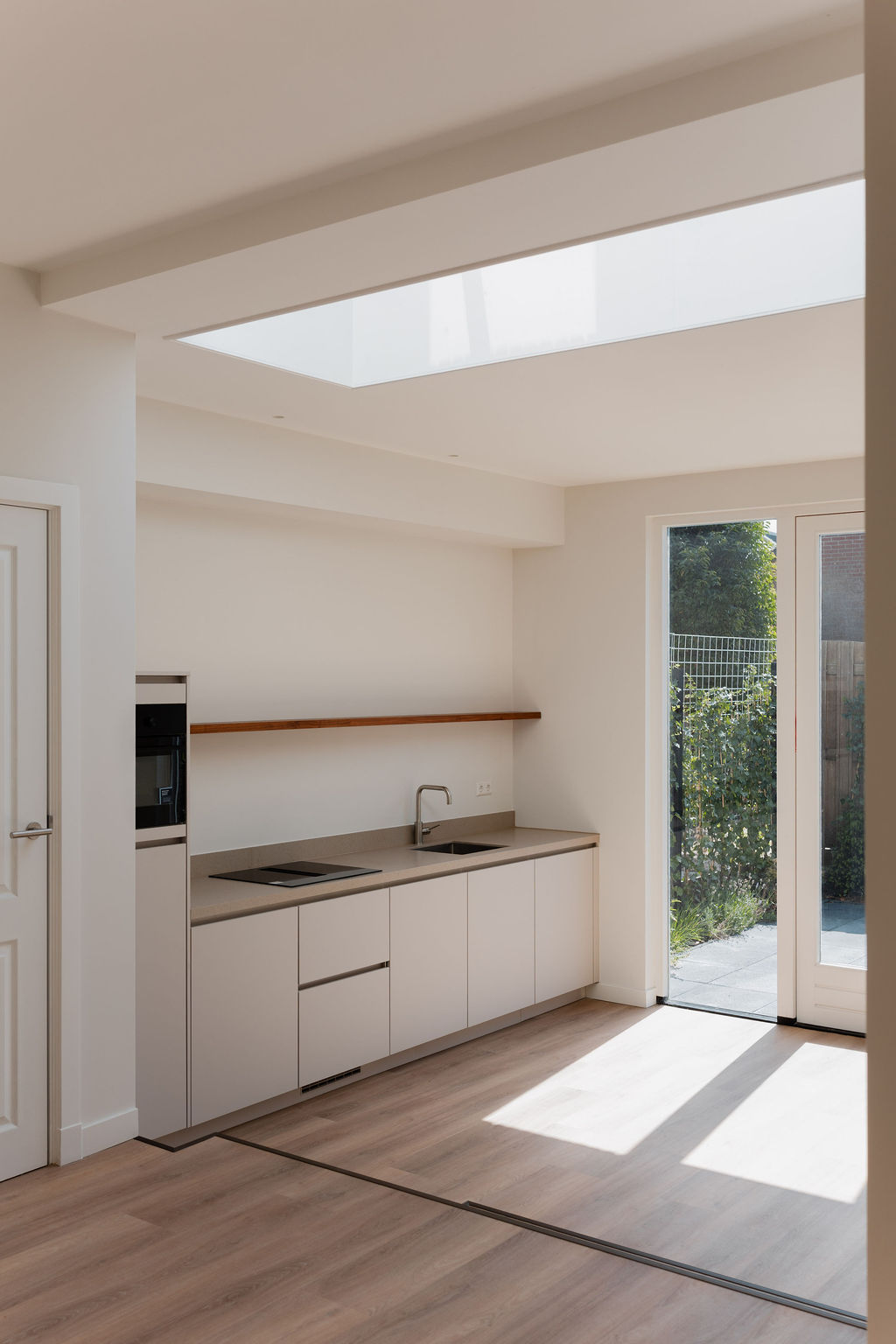 Moderne minimalistische keuken met daklicht en houten accenten