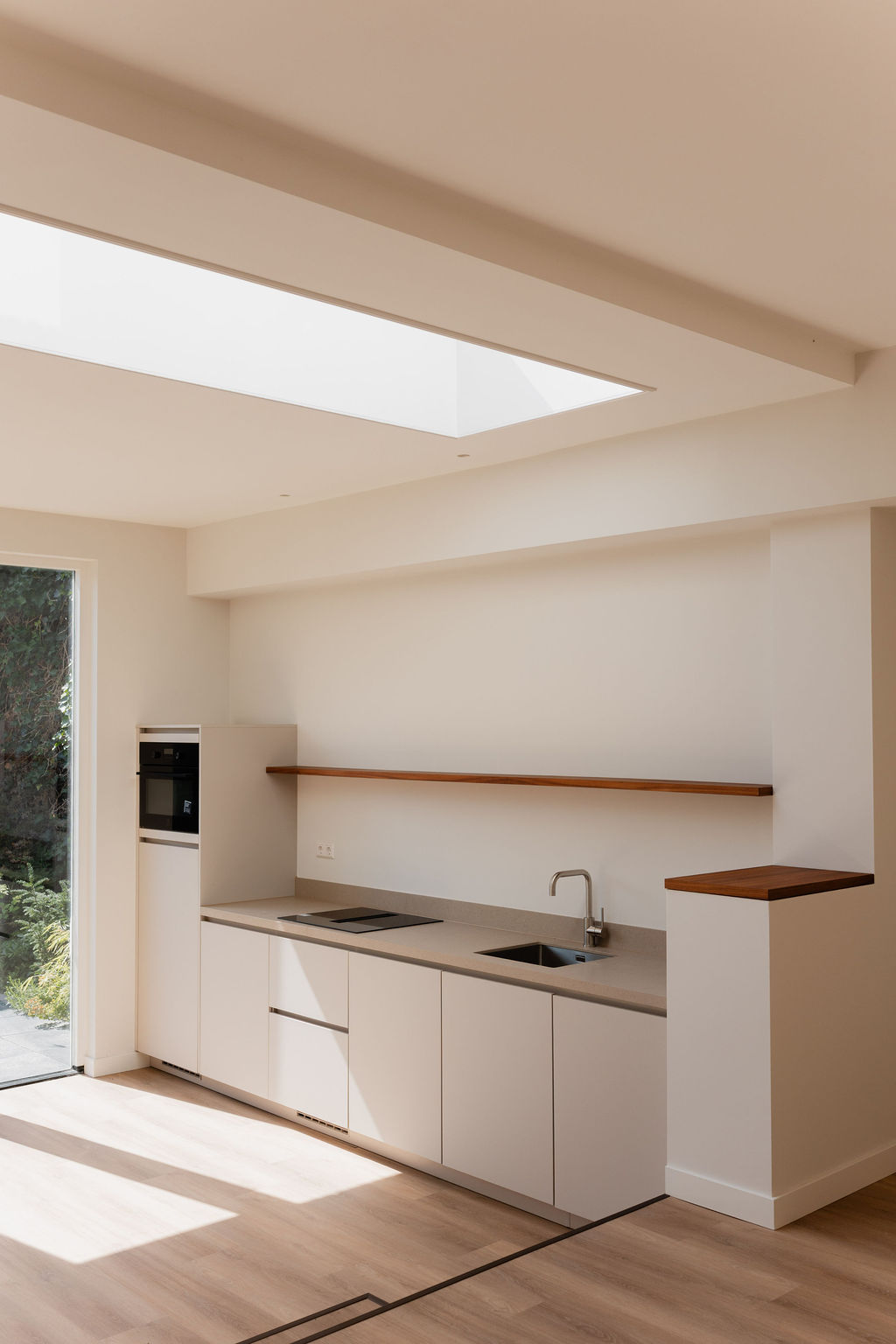 Moderne minimalistische keuken met daklicht en houten accenten