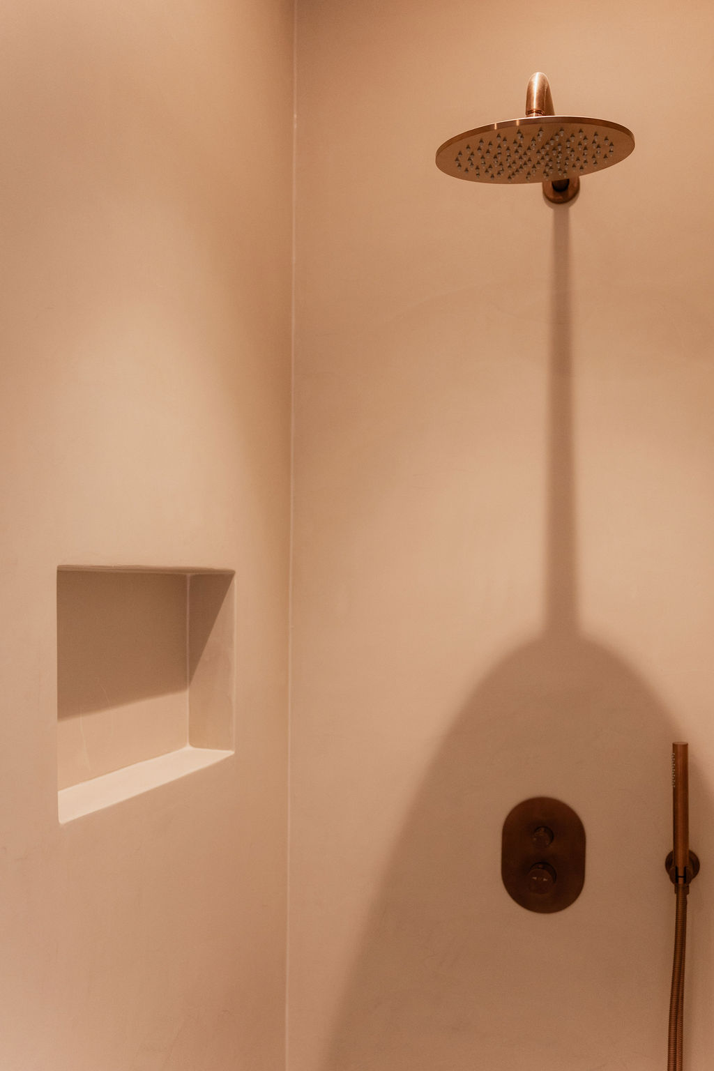 Warme badkamer met koperkleurige kranen en maatwerk wastafelmeubel