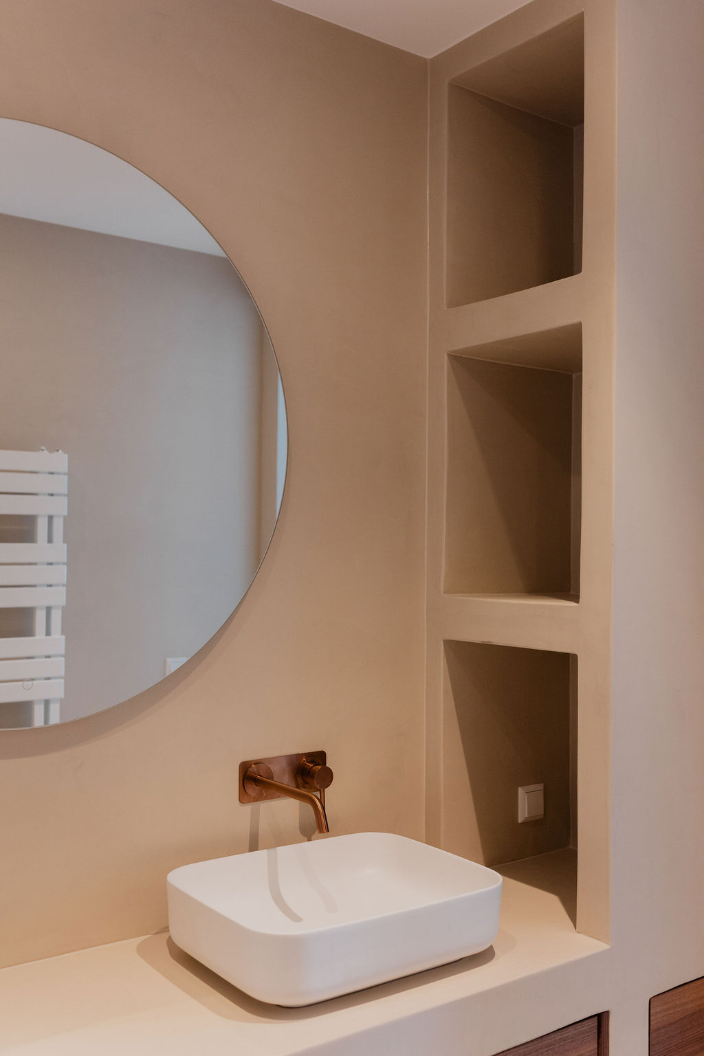 Warme badkamer met koperkleurige kranen en maatwerk wastafelmeubel