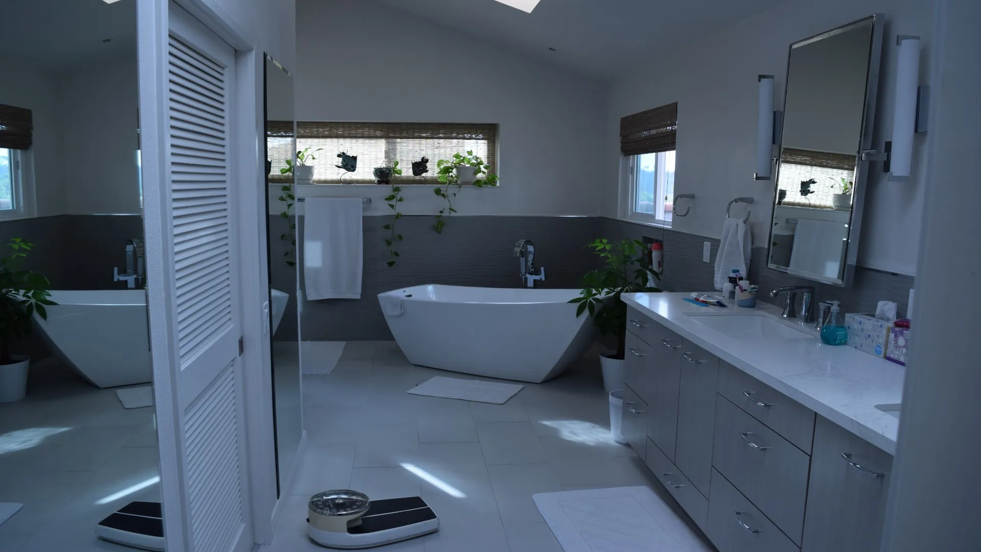 Primary bathroom with a freestanding tub and gray double vanity