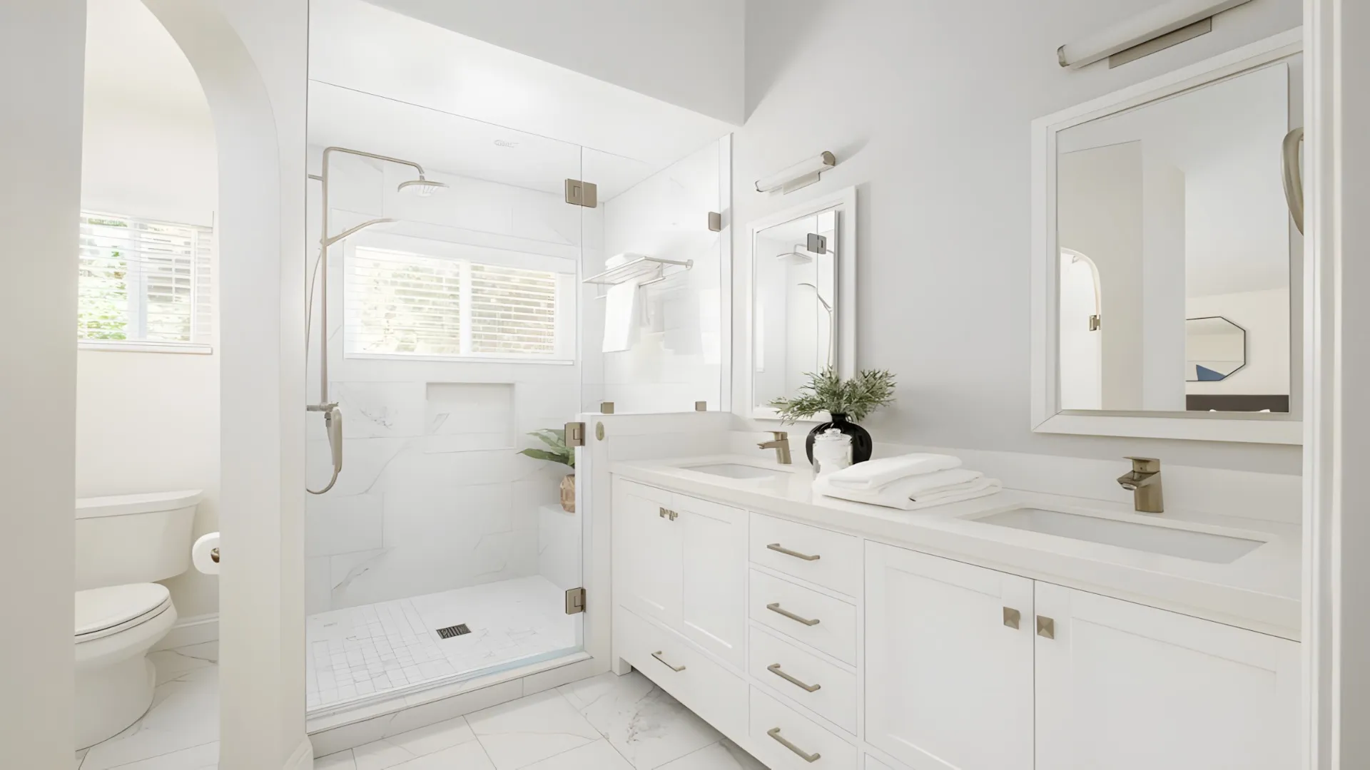 White bathroom with a double vanity and glass walk-in shower