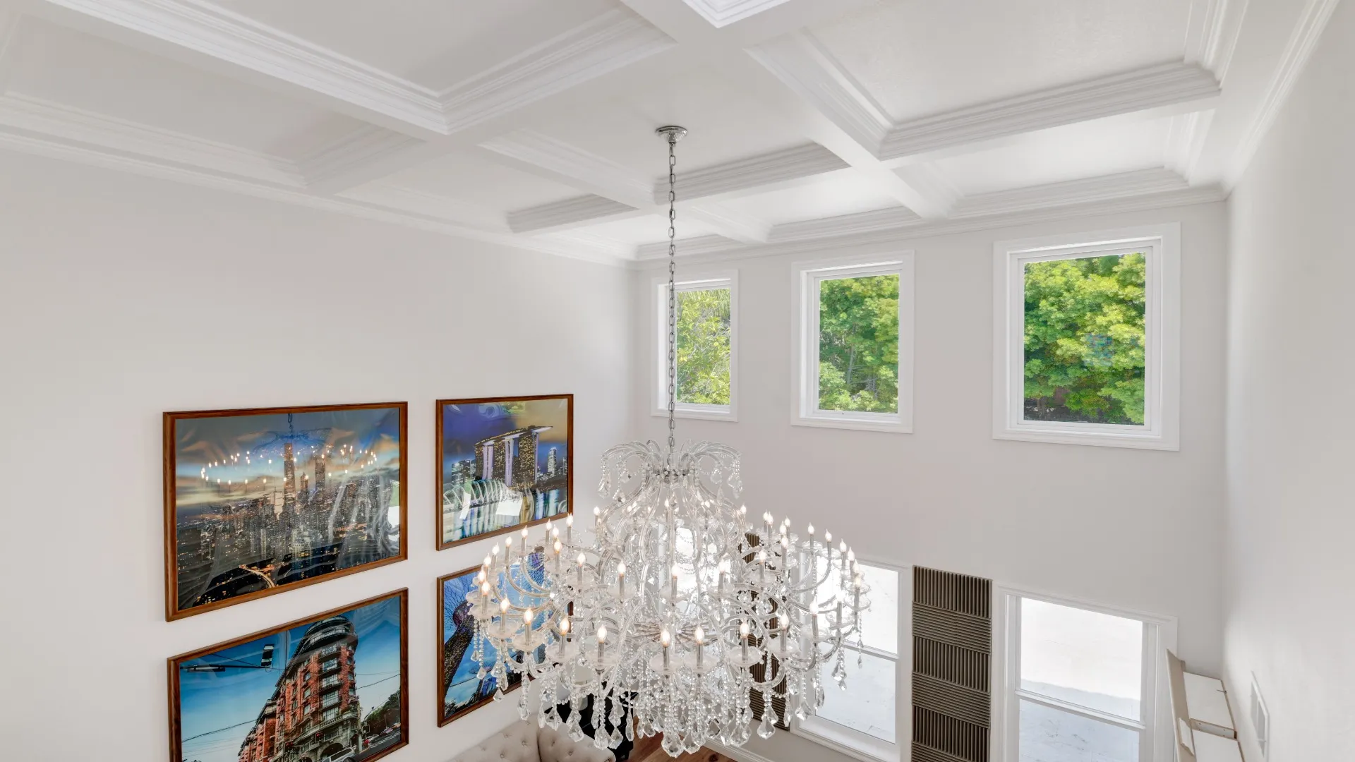 Custom coffered ceiling molding and a crystal chandelier in a two-story entry