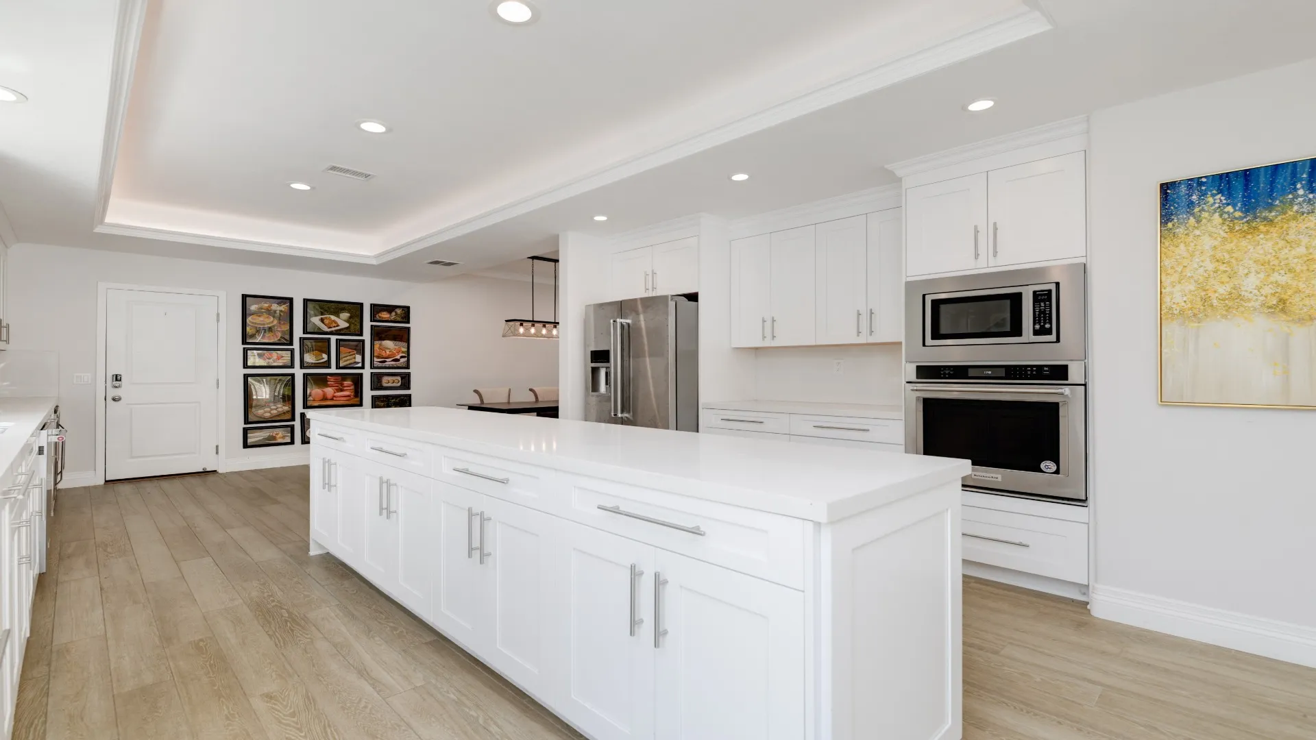 White kitchen with a large island and stainless wall ovens
