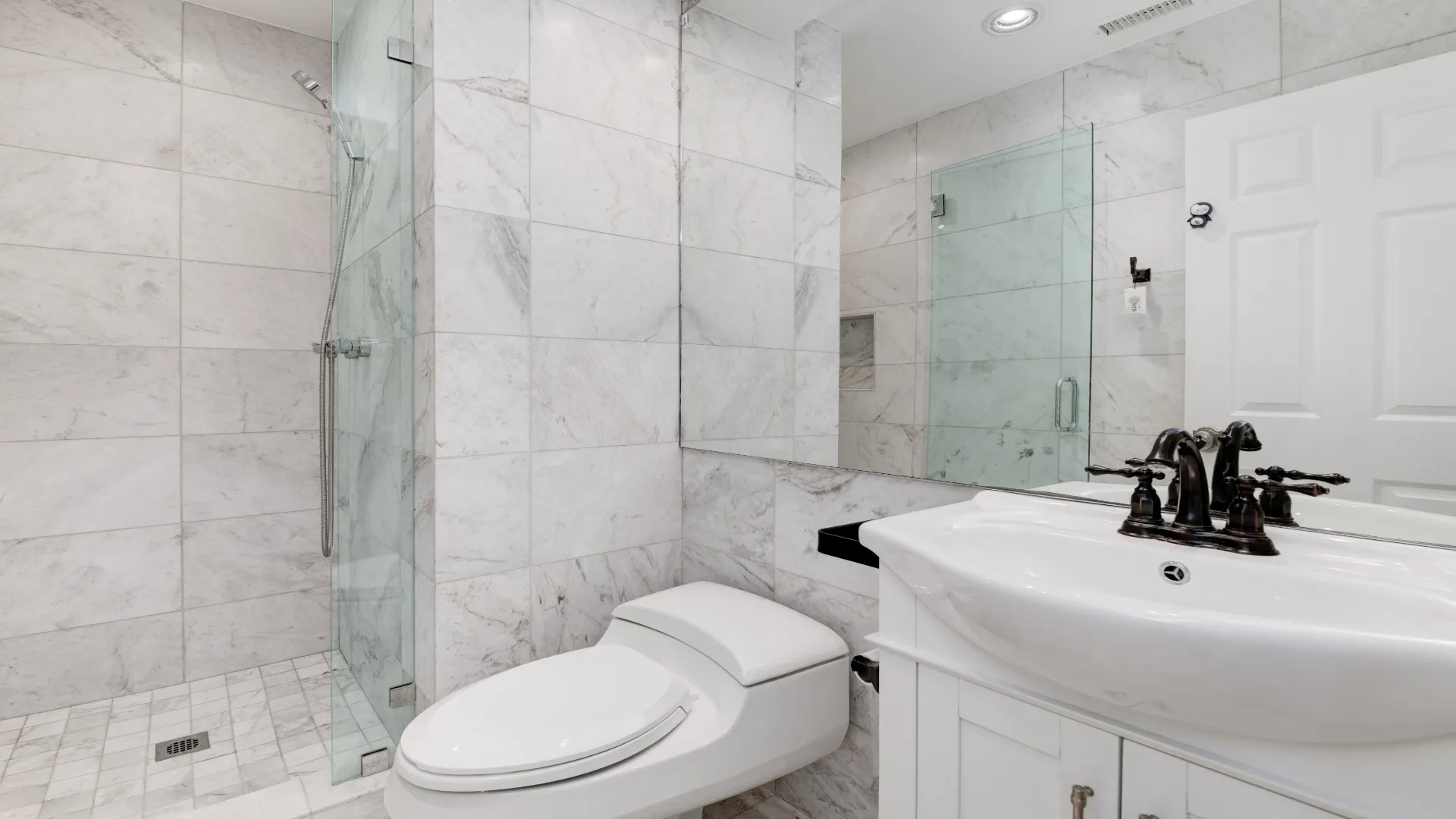 Marble-tile bathroom with a frameless glass shower