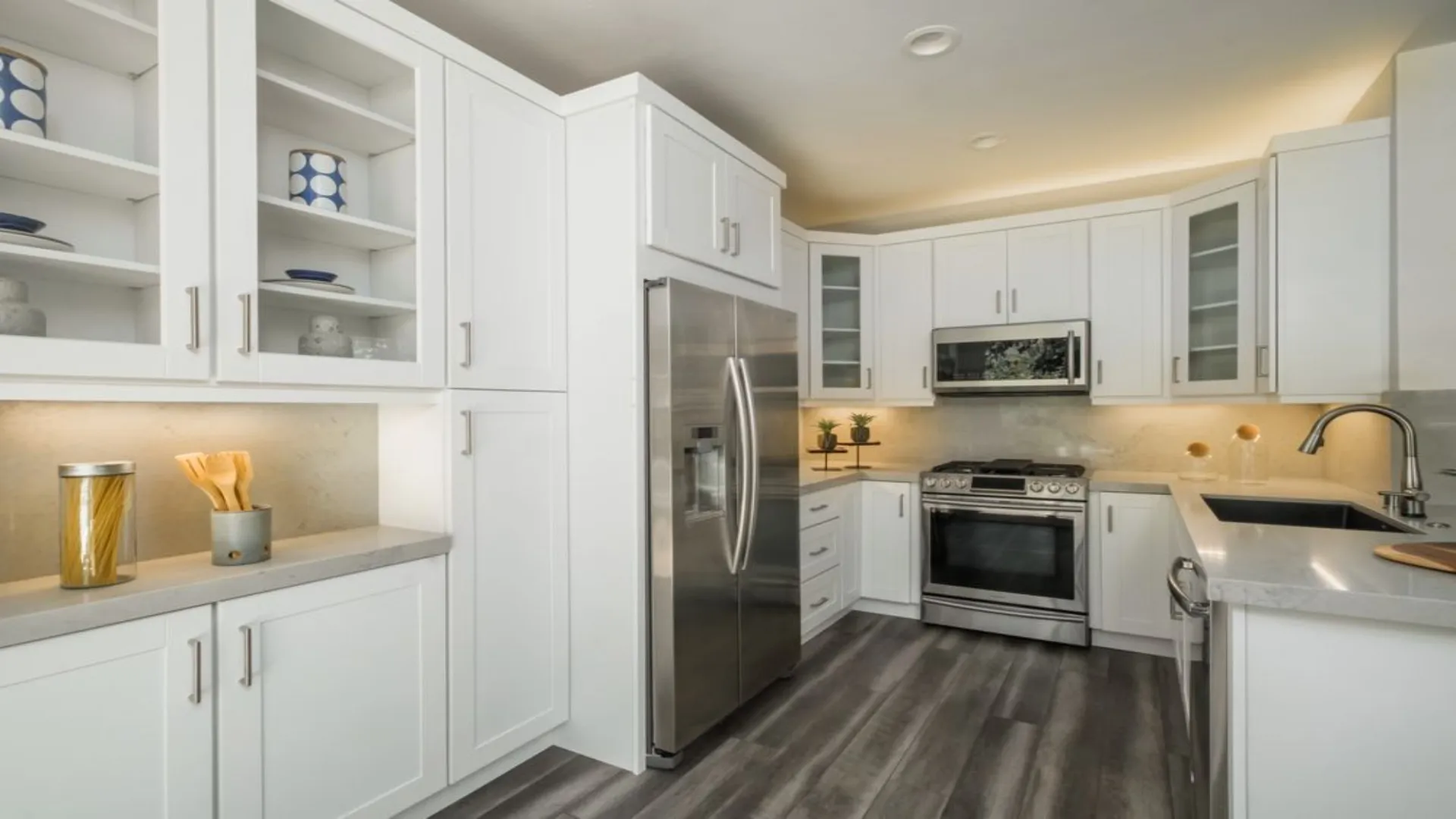 White kitchen with glass-front cabinets and stainless appliances