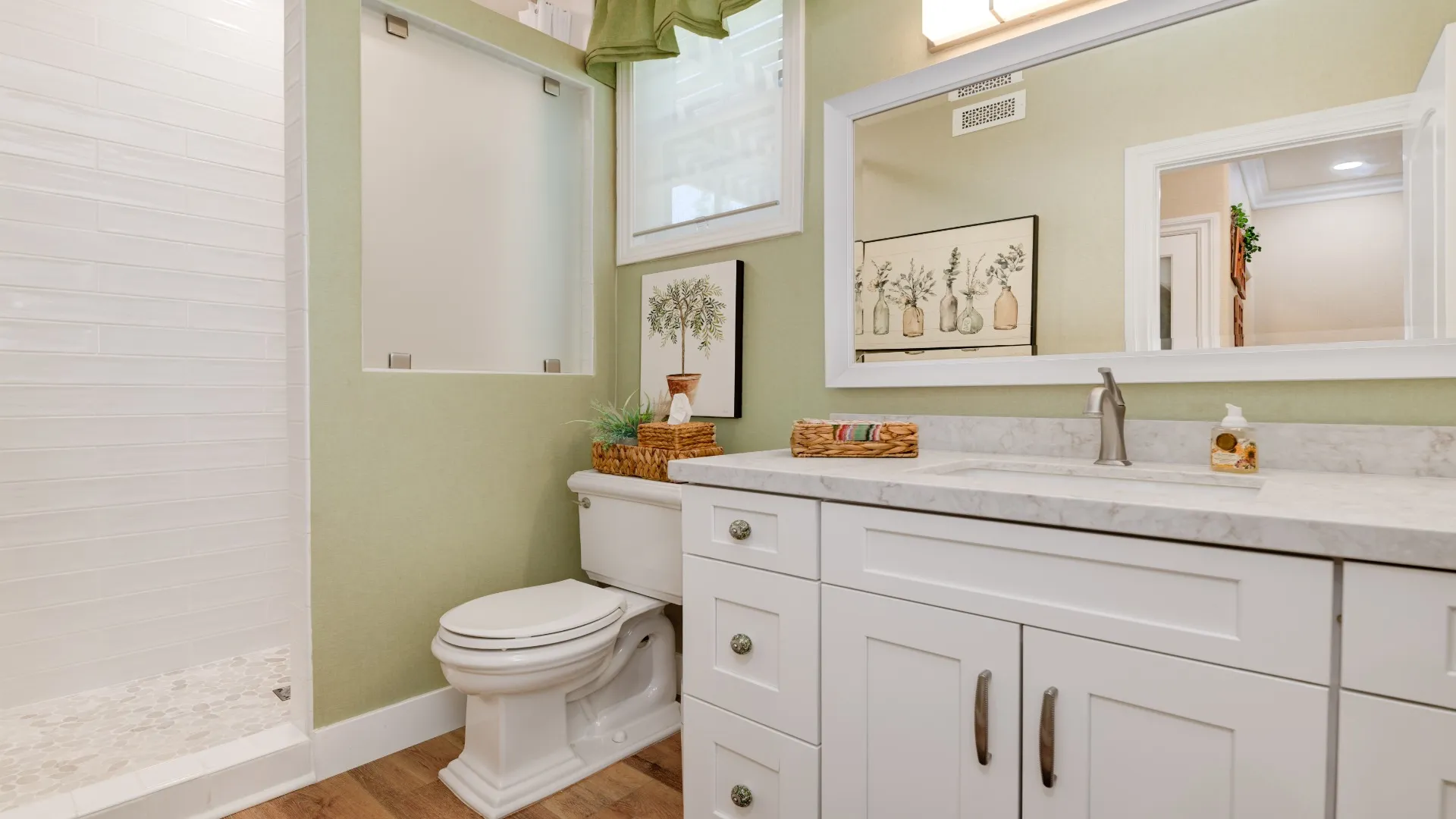 Bathroom with a white vanity, framed mirror and walk-in shower