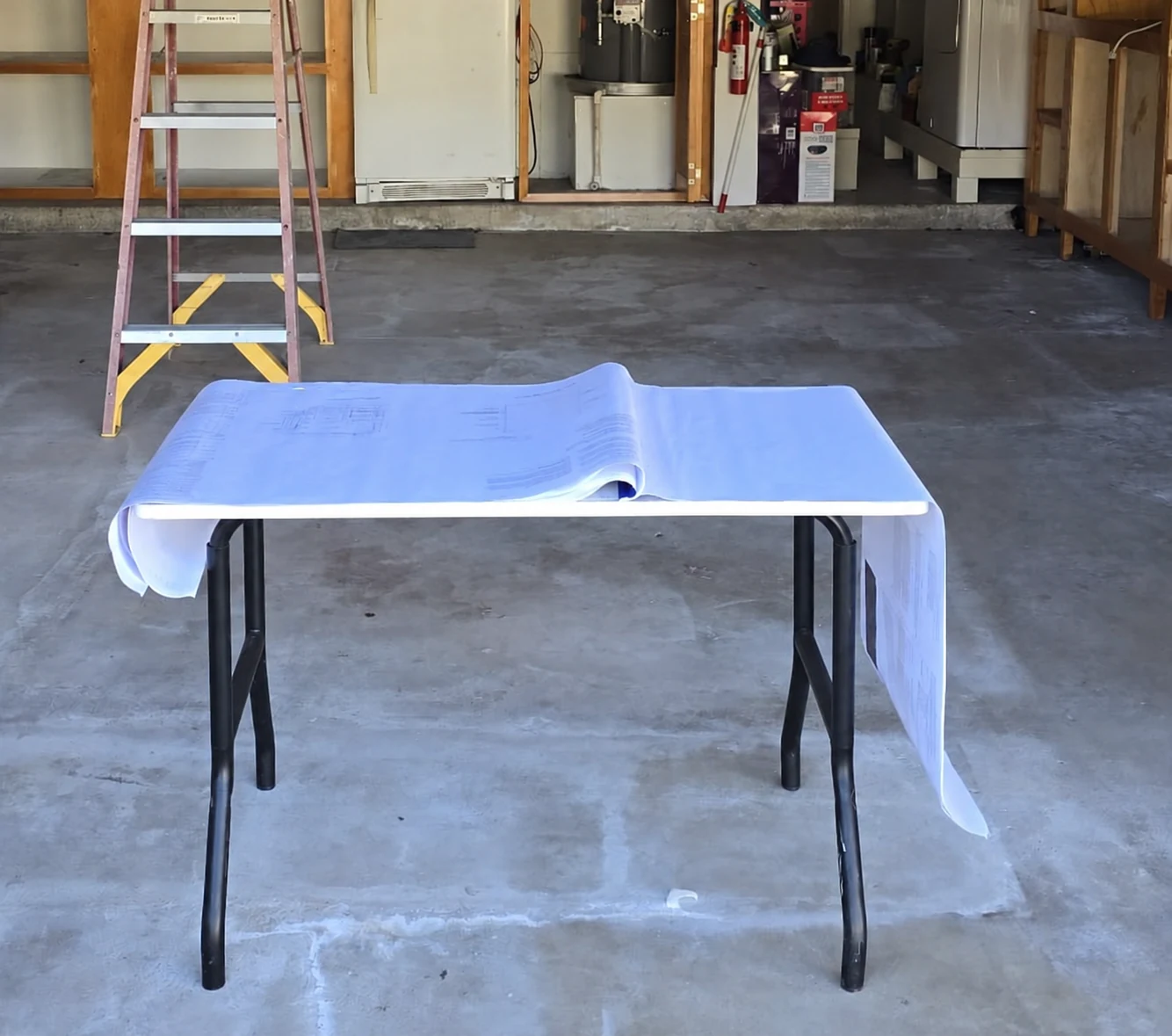 Plans on a table inside a garage before the conversion