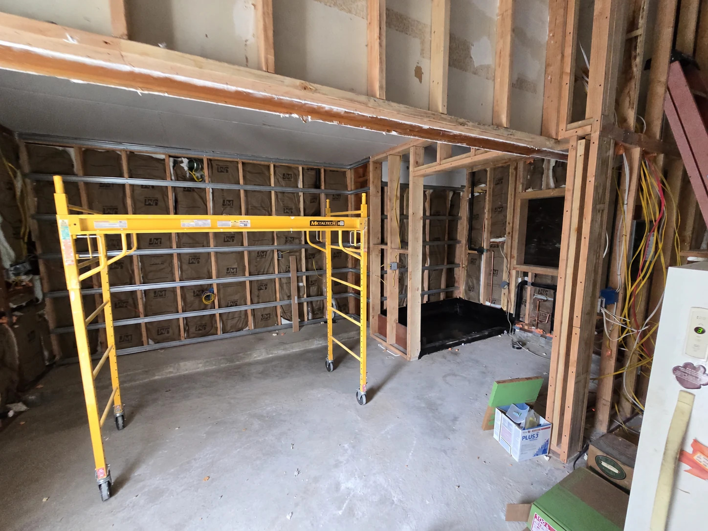 Garage with open framing, wiring and scaffolding during the conversion