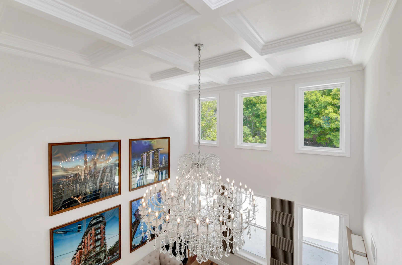 Custom coffered ceiling molding and a crystal chandelier in a two-story entry