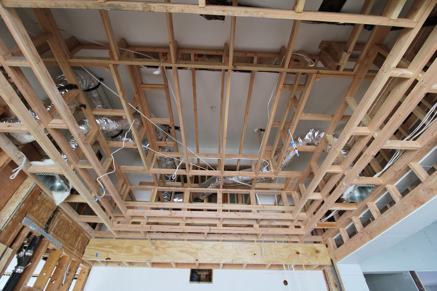 Reverse step ceiling framing with ductwork and wiring in an addition