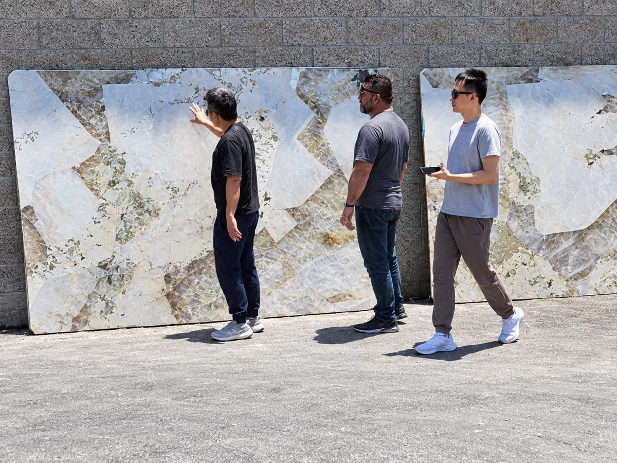 Victor with clients at a stone yard, planning where each slab will be cut and which room each piece goes in