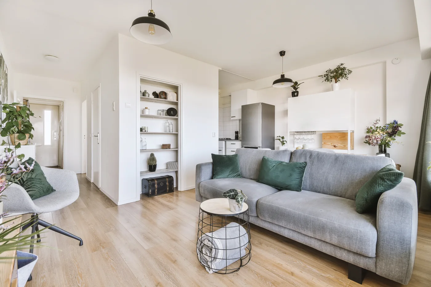 Finished ADU living room with a gray sofa and the kitchen beyond
