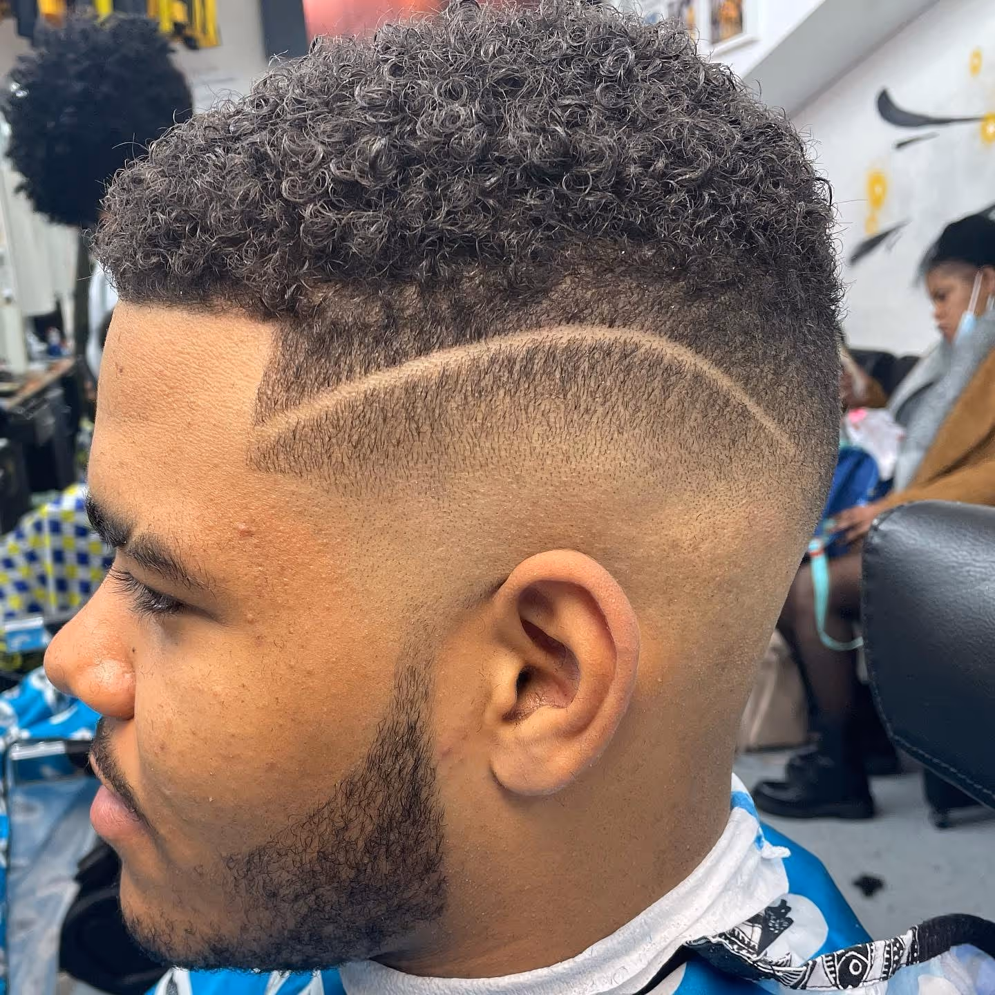 Mid fade haircut with line art at Fineboy Barbershop Bern