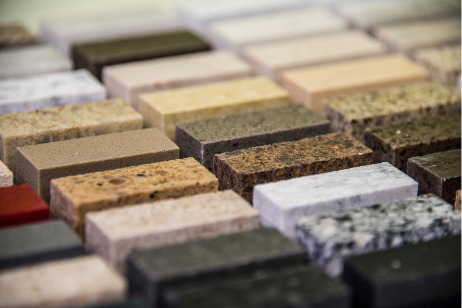 ChatGPT said:
Various large slabs of natural stone including marble and granite in different colors and patterns, arranged vertically in rows at a stone supplier or showroom.