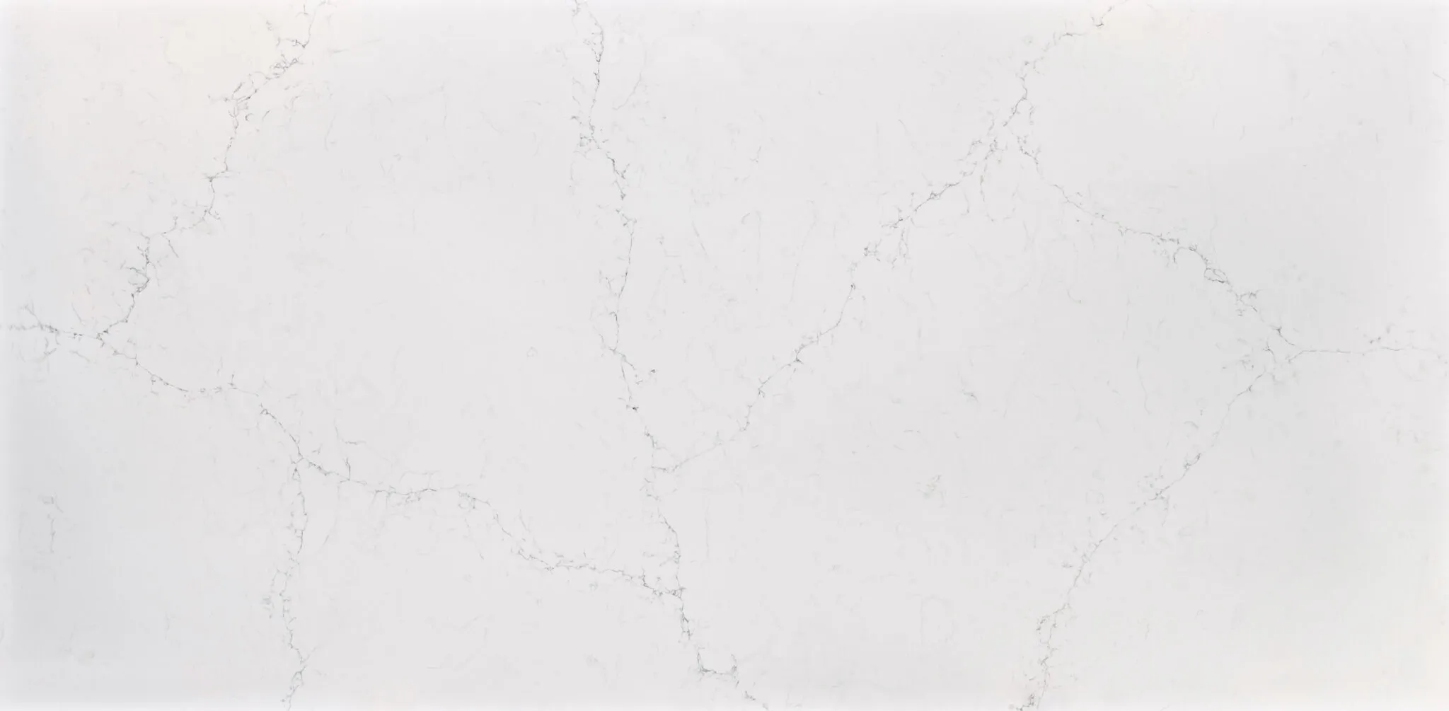 White marble surface with subtle gray veining patterns, resembling a clean and elegant quartz countertop design.