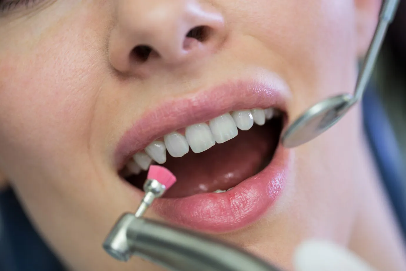 Patient viewing her new smile in a hand mirror during a veneer consultation