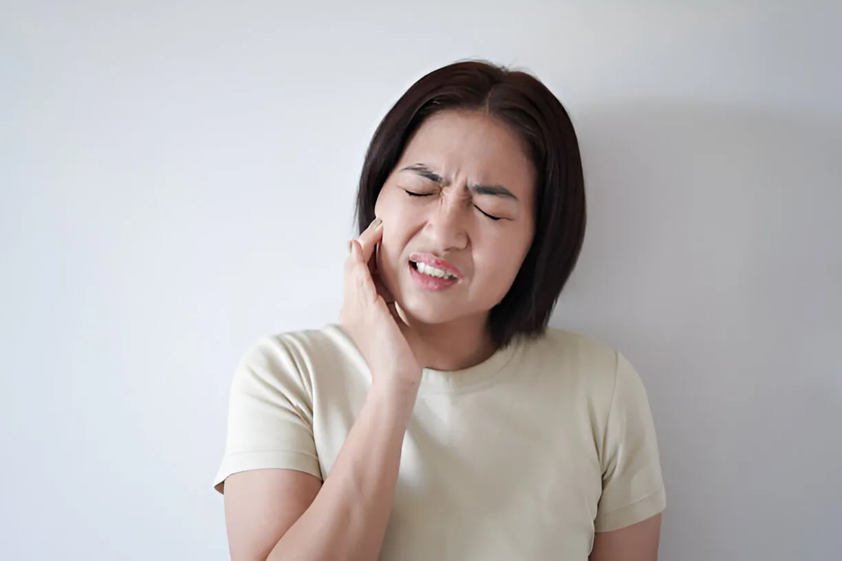 Woman holding her cheek in pain