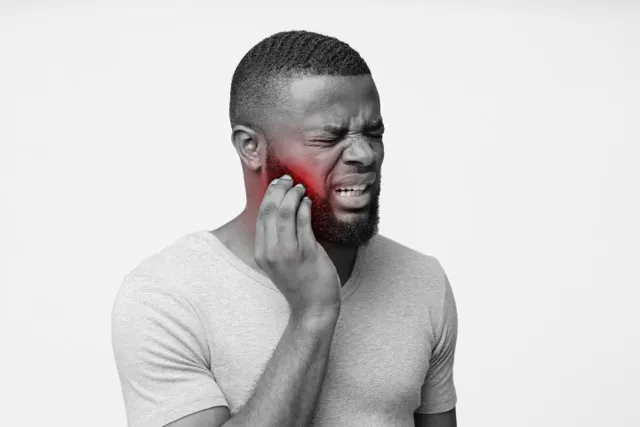 Man holding his jaw with a highlighted area showing tooth pain