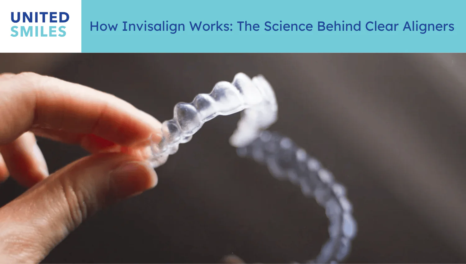 Hand holding a transparent Invisalign clear aligner