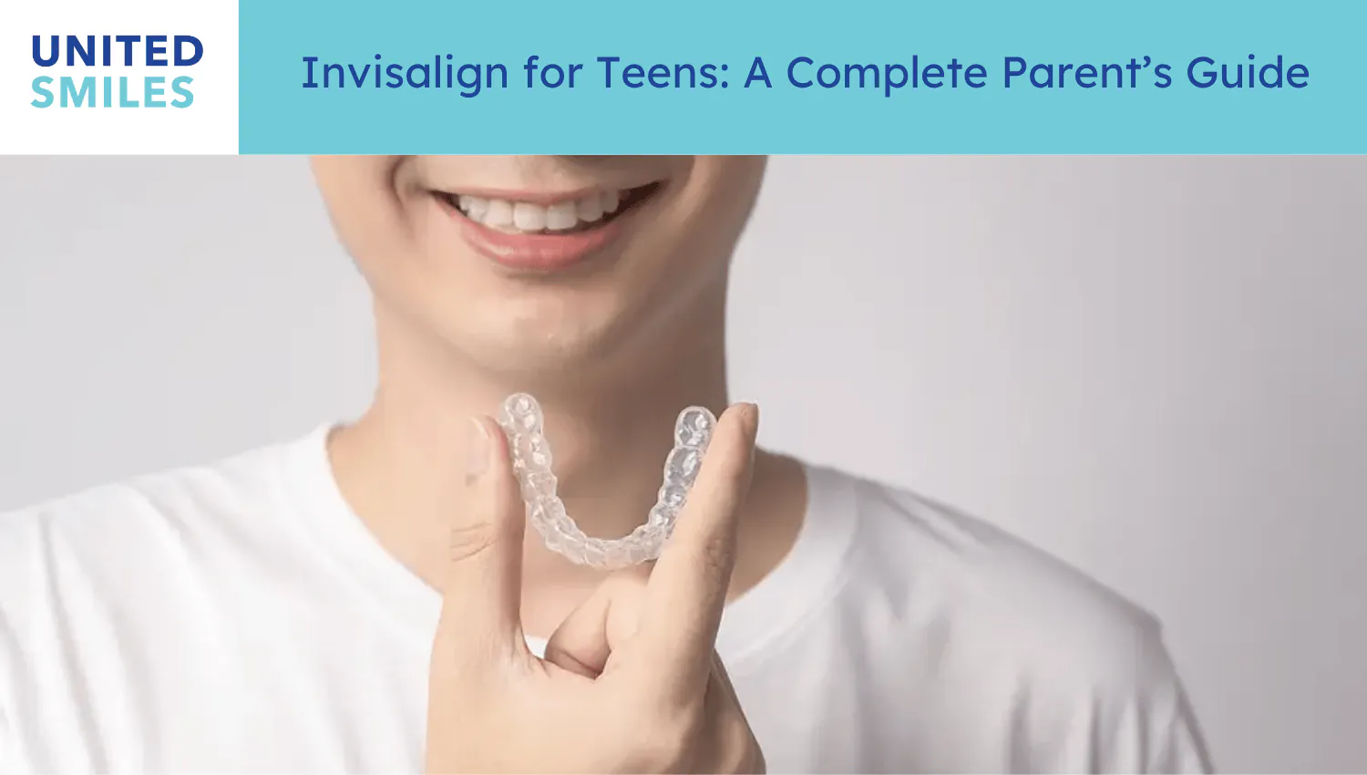 Smiling teenager holding a clear Invisalign aligner tray