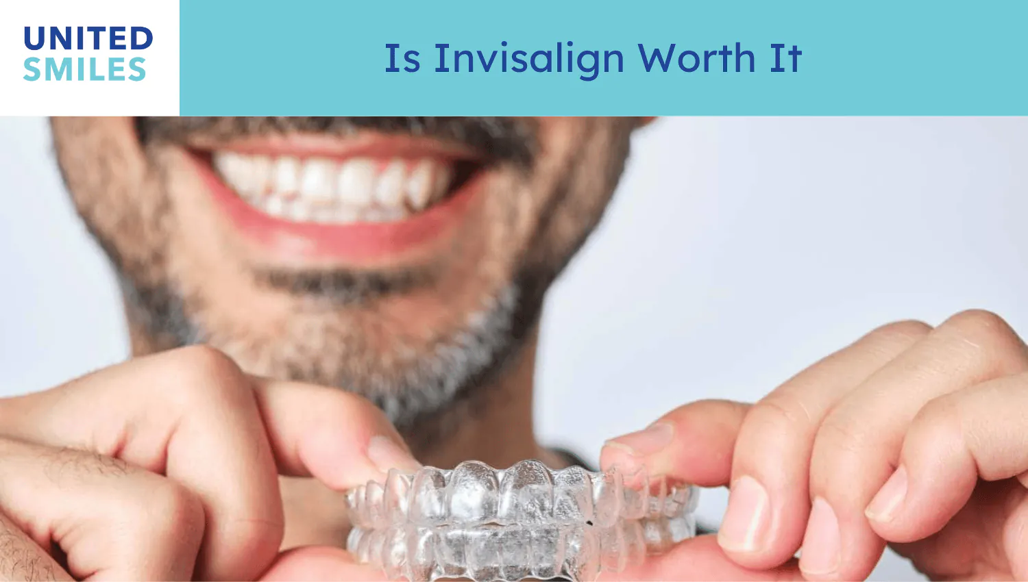 Man smiling while holding a clear Invisalign aligner