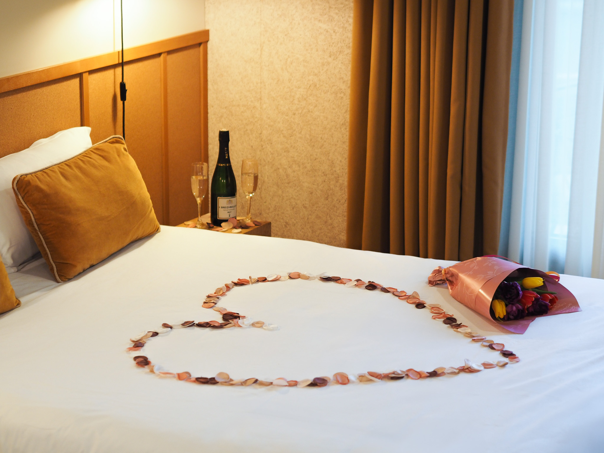 Pétales de fleurs, avec bouquet de tulipes et bouteille de Breizhbulles dans une chambre double à l'Hôtel Oré, Hôtel 4 étoiles à Saint-Malo