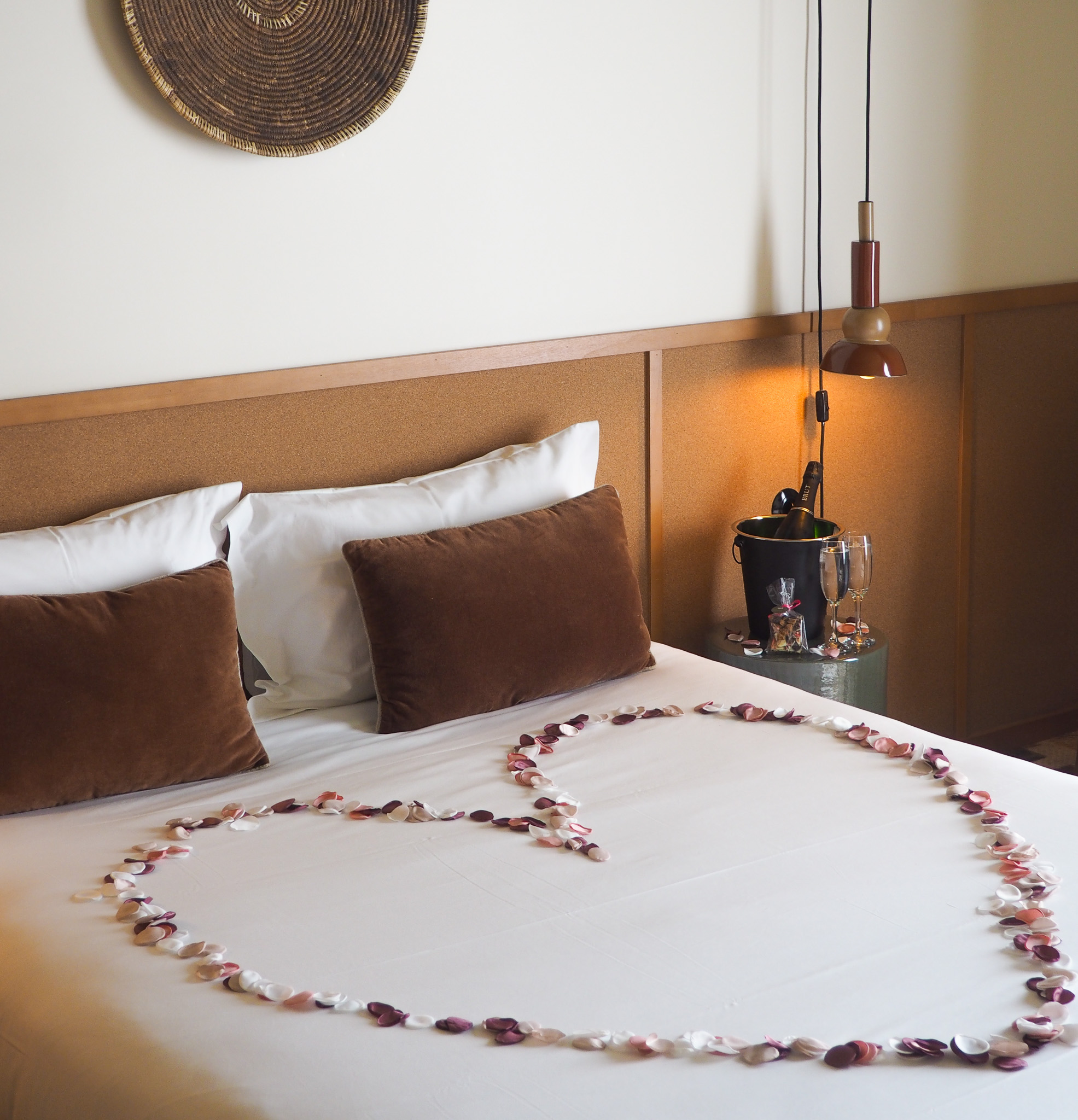 Pétales de fleurs en forme de coeur dans une chambre double à l'Hôtel Oré