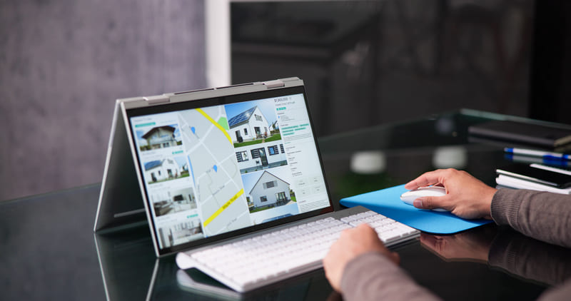 Real estate professional analyzing property listings and housing options on a computer Hiweb