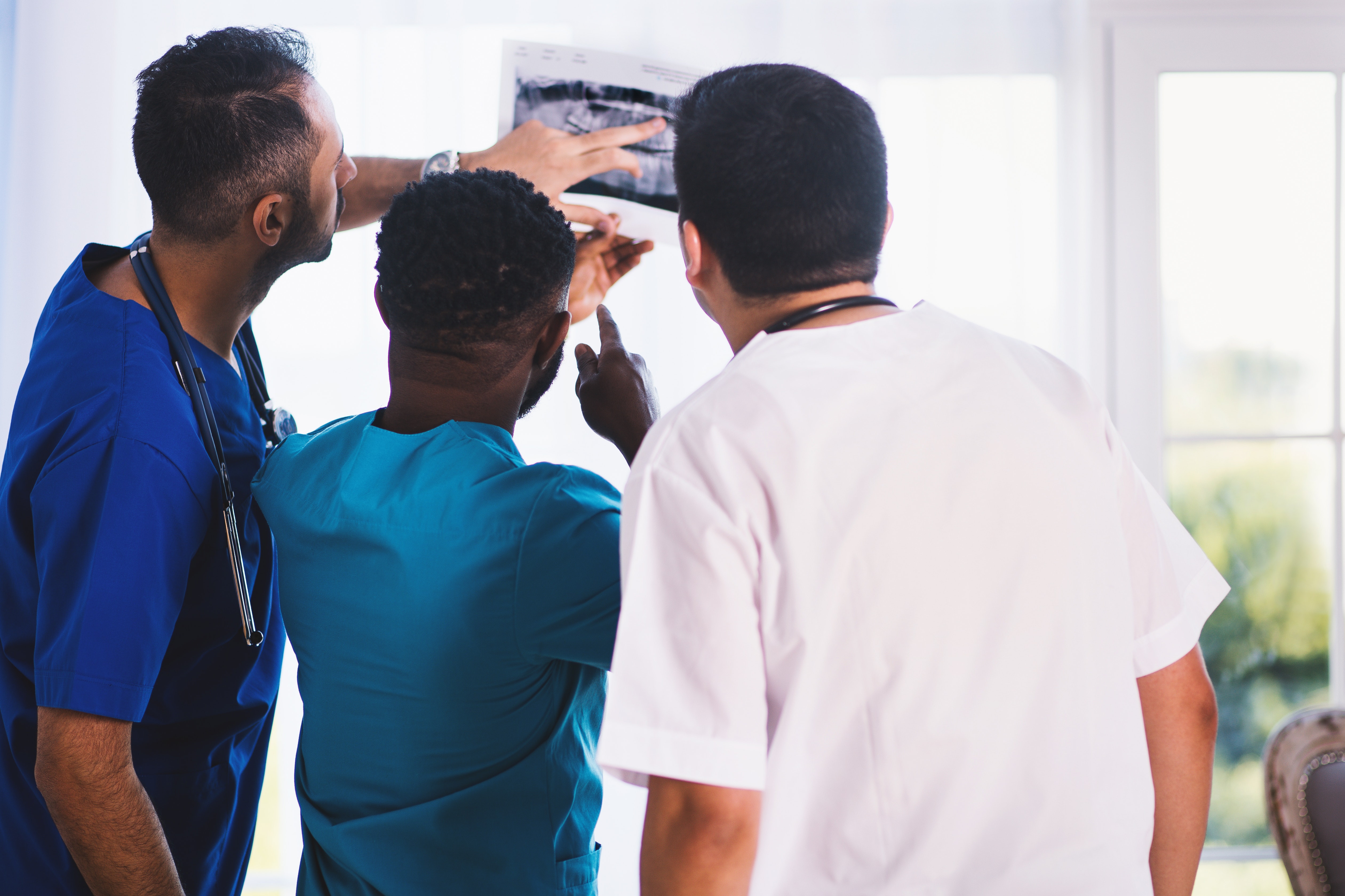 Three male Baptist Health employees assessing an xray in a hospital in Arkansas