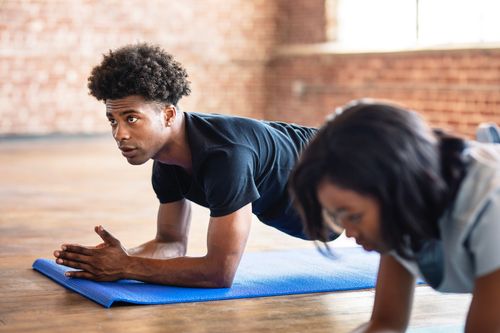 Two people planking at the gym