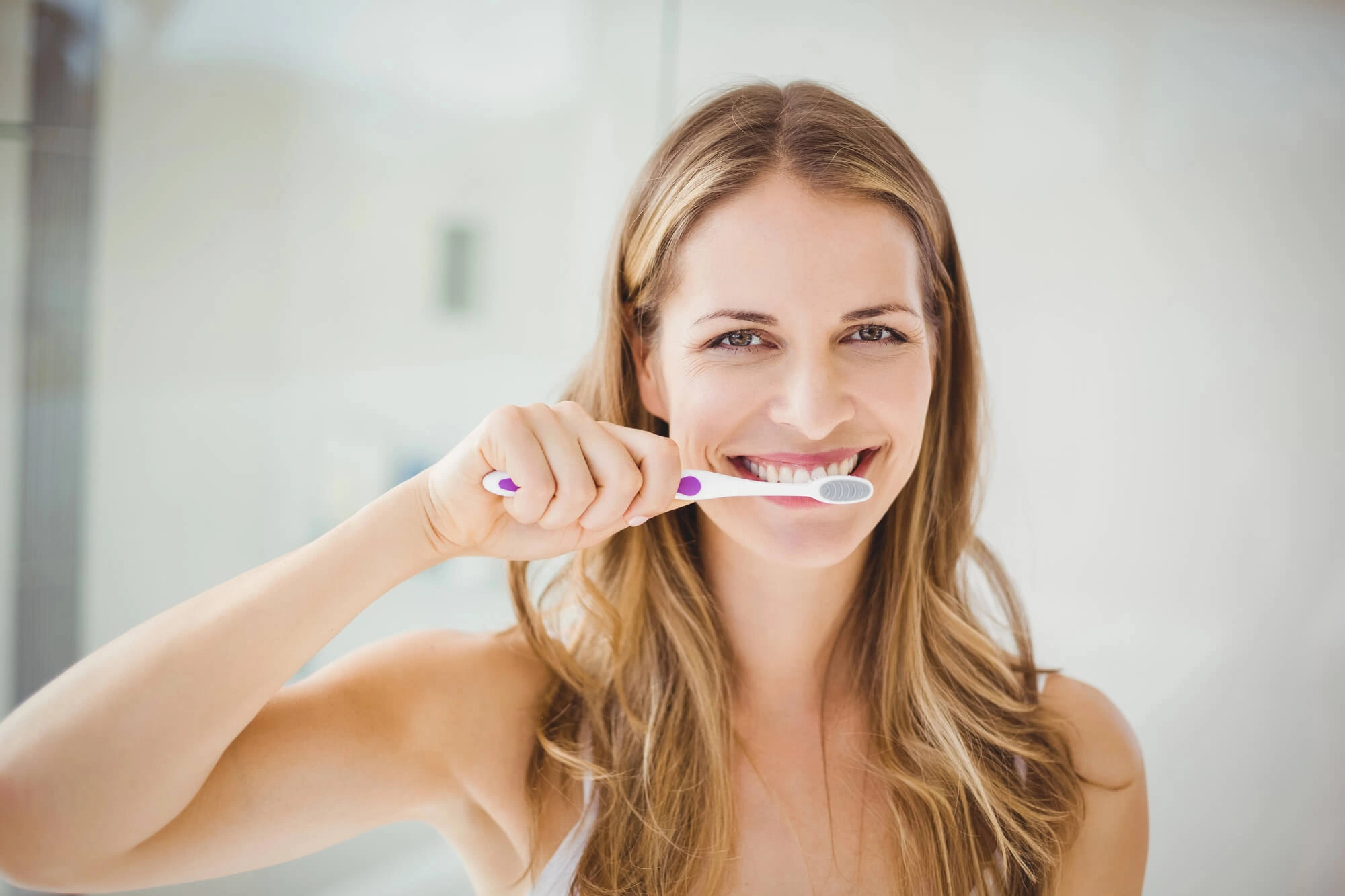 Woman brushing teeth instructed by dentist near levittown ny