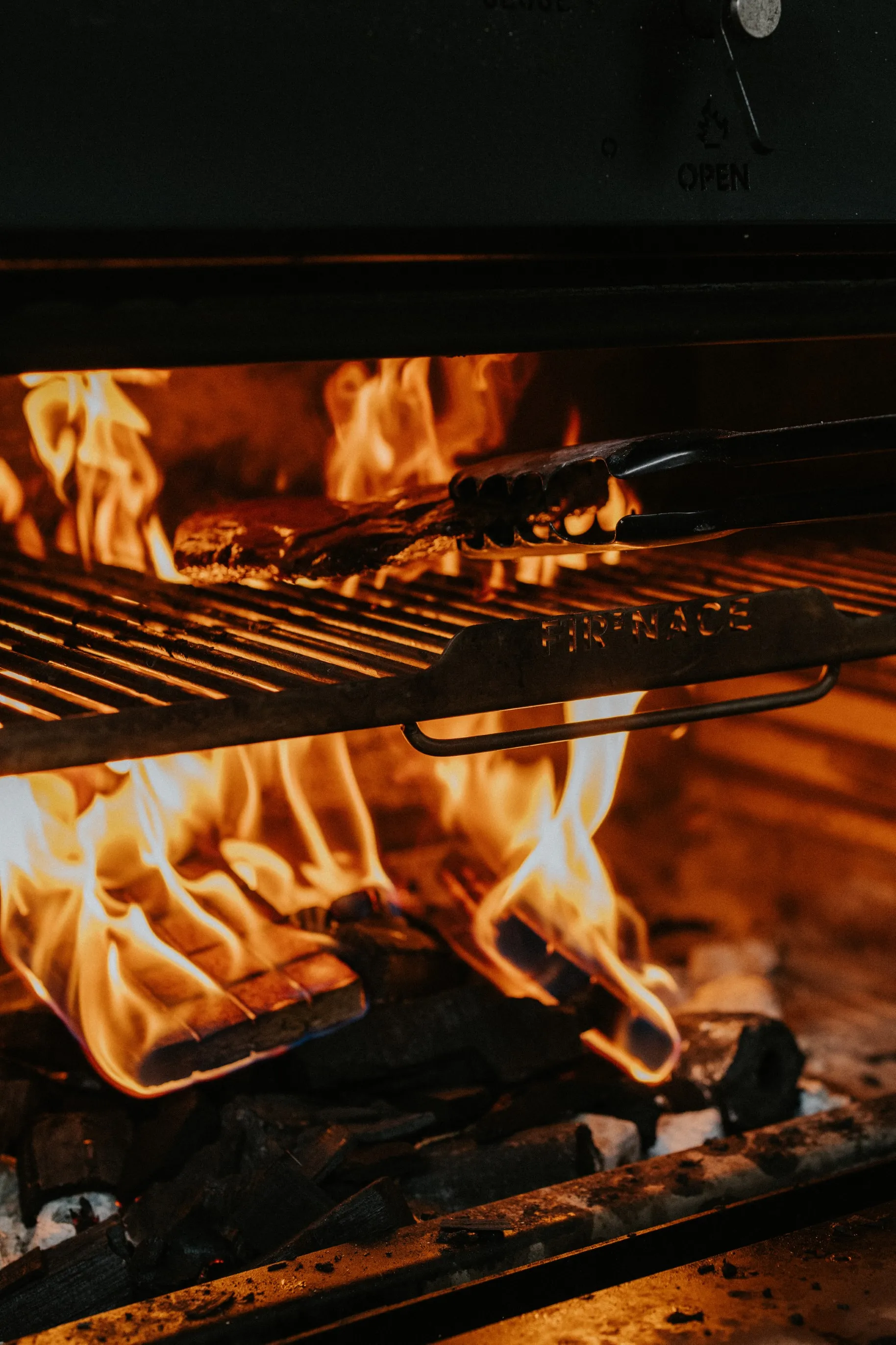 A grill with flames and food being cooked on it