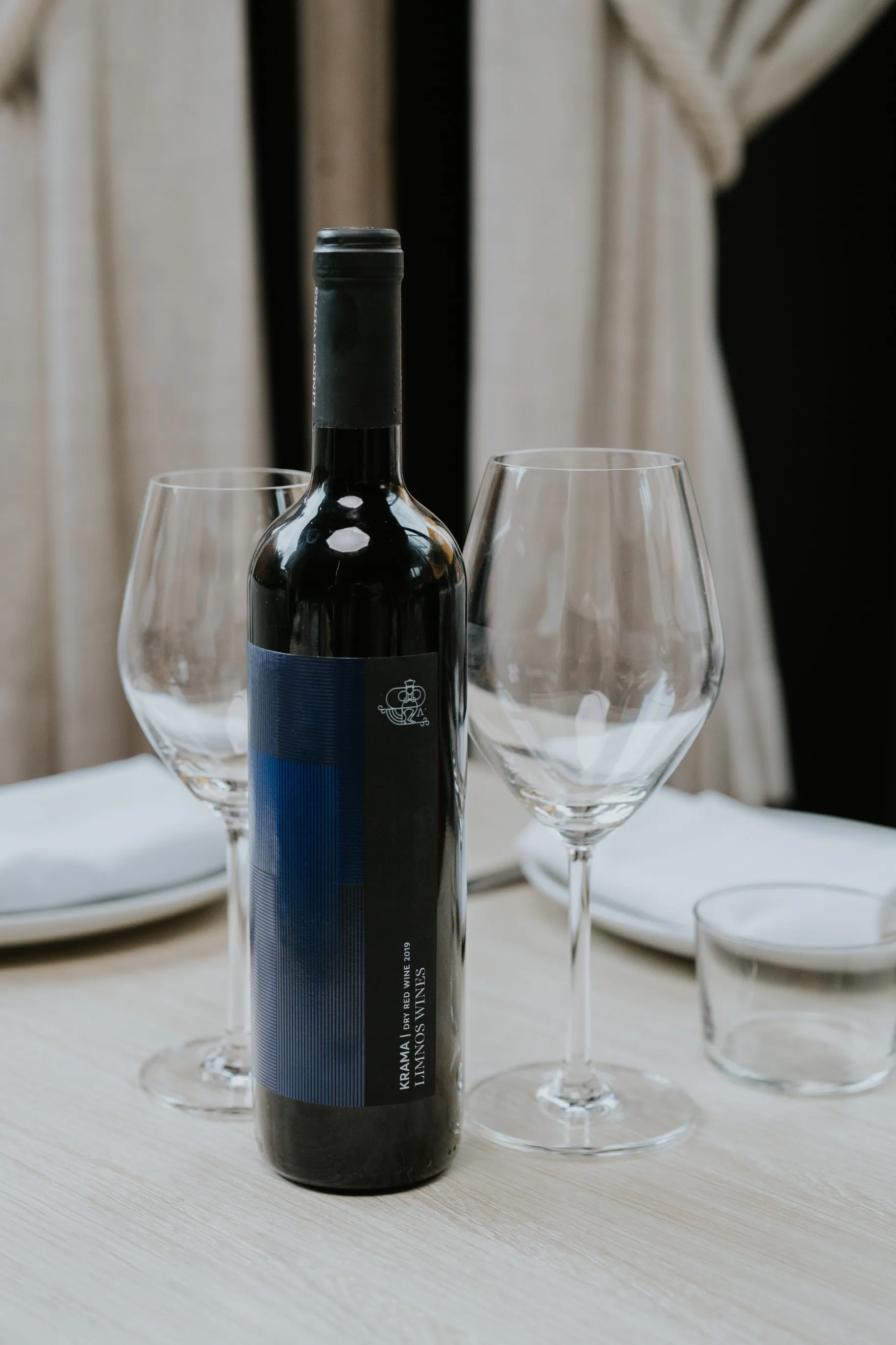 A bottle of wine and two empty wine glasses on a table, ready for a relaxing evening. Cheers! 🍷🥂